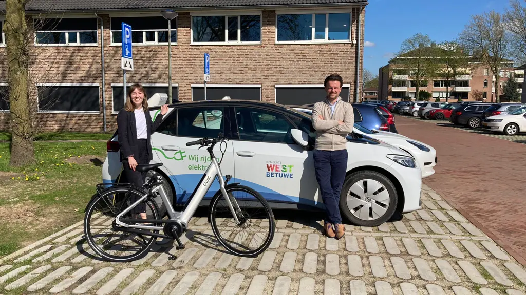 Jasper en Sofie met elektrische fiets bij elektrische auto Gemeente West Betuwe